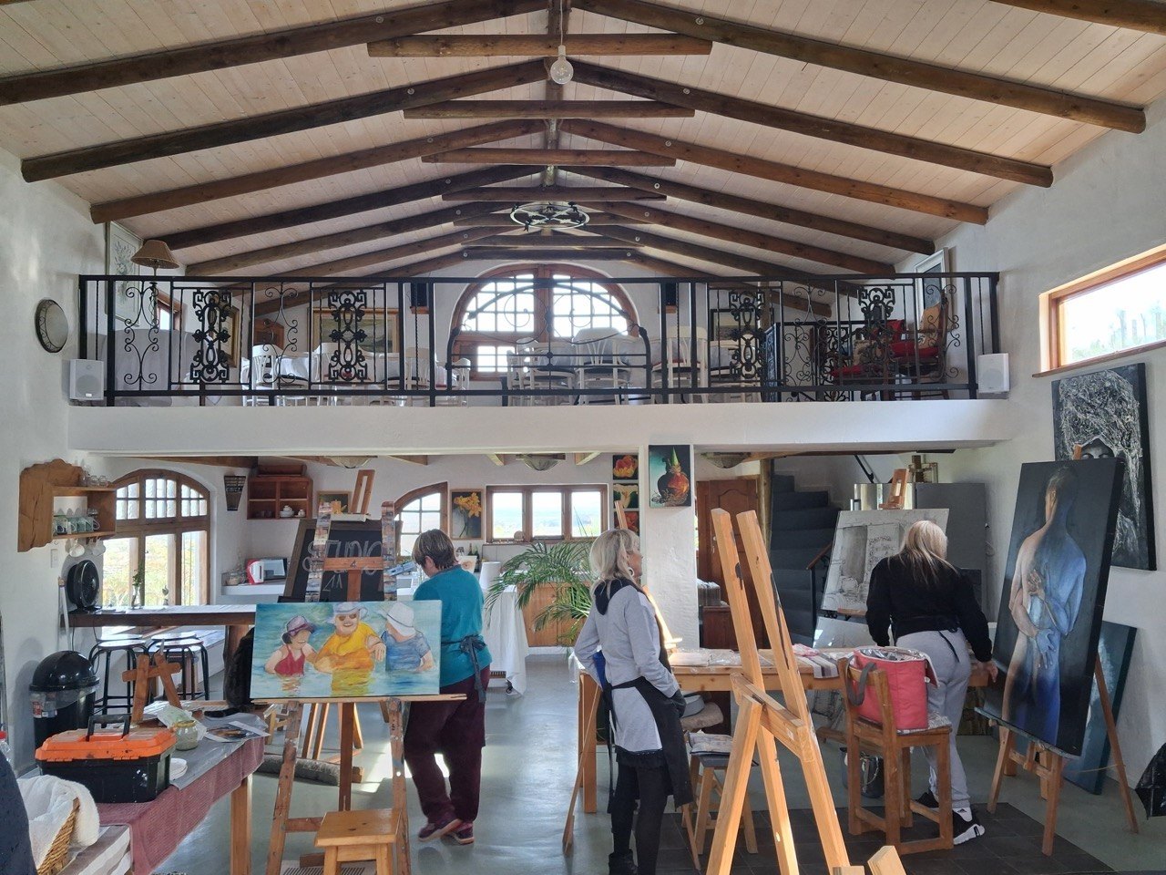 The garden studio at Cobwebs, easels set up under the timber beams with artists painting