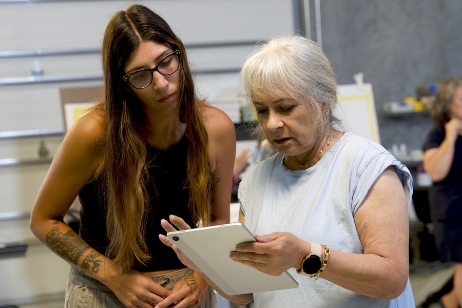 Instructor and student reviewing a sketch together, both smiling