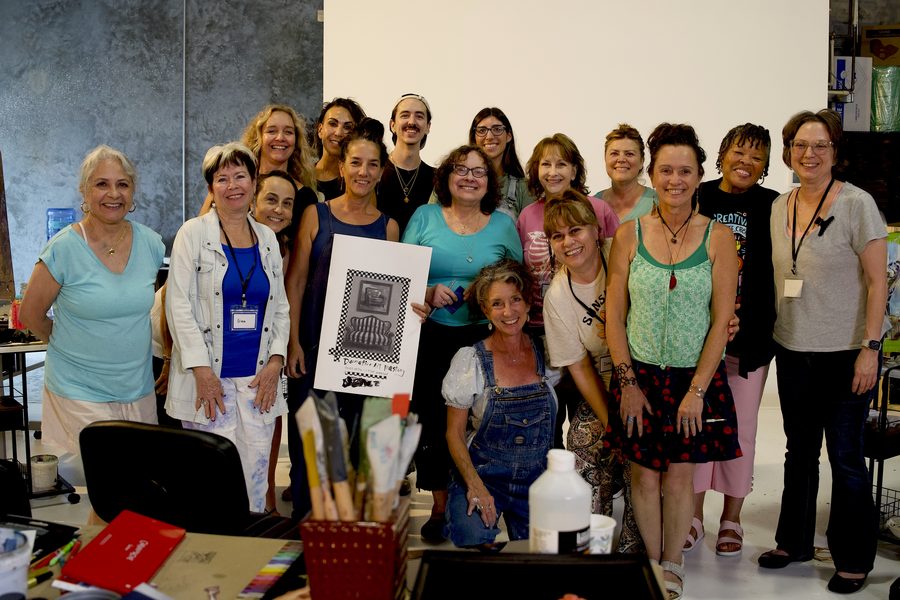 Happy workshop group posing together with a finished painting